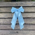 Détail d'une pince à cheveux avec nœud en satin bleu ciel et longs rubans sur bois - Bleu 308