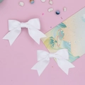 Close-up of white grosgrain ribbon swallowtail hair bows on a soft pink background - 2-Piece Set / White