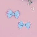 Detail of light blue ribbed hair bows with colorful sprinkles on pink background - Blue