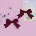 Detailed close-up of wine red swallowtail bow hair clips with textured grosgrain fabric - 2-Piece Set / Burgundy