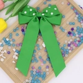 Dettaglio di un grande fiocco per capelli in gros-grain verde a pois bianchi con nastri - Verde scuro