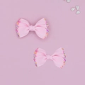 Dettaglio di fiocchi per capelli in grosgrain rosa con perline colorate per bimbe - Rosa