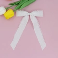 Detail einer weißen Spitzen-Haarklammer mit langen Bändern und filigranen Blumenmustern - Weiß