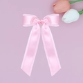 Detalle de una pinza para el cabello con lazo doble de satén rosa claro y acabado brillante - Rosa