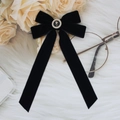 Elegant black velvet bow hair clip with pearl rose charm on a soft white plush background - Black