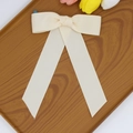 Détail de la pince à cheveux nœud en ruban côtelé crème avec de longs rubans - Mètre