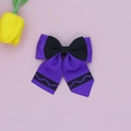 Detail of purple and black ribbon hair bow with wavy patterns and elegant long streamers - Purple