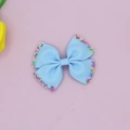 Close-up of blue grosgrain ribbon bow hair clip with colorful candy sprinkles detail - Light Blue