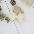 Close-up of beige lace bow hair clip with silver star rhinestone center on white wood - Beige