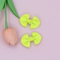 Detail of neon yellow ribbed ribbon hair bows placed on a pink background with a tulip - Neon Yellow