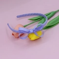 Detail of light purple ribbed bow headband on soft pink background with flowers - Light Purple