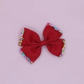 Close-up of red grosgrain ribbon hair bow with colorful candy sprinkle edges - Red