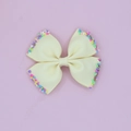 Detail view of beige ribbed grosgrain hair bow clip with colorful candy sprinkle accents - Beige