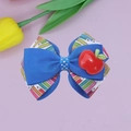 Close-up of Back to School hair bow featuring pencil patterns and a red apple resin charm - Sapphire Blue