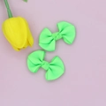 Macro detail of pair of fluorescent green ribbed ribbon bow hair clips on pink surface - Fluorescent Green