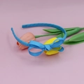 Sky blue grosgrain ribbon headband with matching bow, styled with pink tulip flowers - Lake Blue