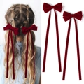 Detail of dark red velvet bow hair clips with long ribbons on model and white backdrop - Burgundy