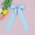 Détail d'un nœud papillon en satin bleu clair avec de longs rubans à l'aspect soyeux - Bleu clair