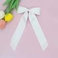 Détail d'un nœud papillon en satin blanc avec longs rubans sur fond de tulipes roses - Blanc