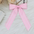 Detailed view of pink lace double bow hair clip on a soft white plush background - Pink