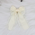 Close-up of elegant beige lace hair clip with polka dot texture and satin fabric - Beige