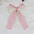 Macro detail of elegant pink satin and white floral lace layered bow hair clip accessory - Pink