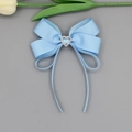 Gros plan d'une pince à cheveux nœud bleu clair avec diamant cœur et rubans élégants - Bleu Or