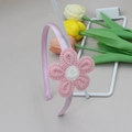 Detail van roze gehaakte zonnebloem hoofdband op een witte metalen standaard - Roze