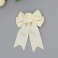 Dettaglio dell'elegante fermaglio per capelli in raso avorio con rosa in tessuto e nastri - Beige