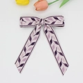 Close-up of purple leaf pattern bow hair clip with long elegant flowing ribbons - Purple