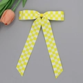 Détail d'une pince à cheveux à carreaux jaunes et blancs avec de longs rubans - Jaune