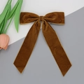 Détail d'une pince à cheveux nœud en velours caramel avec longs rubans et tulipe - café