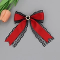 Detail of red satin and black lace bow hair clip featuring a heart shaped gemstone - Red