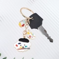 Detail of artist dog enamel keychain with palette charms on striped white background - Painter Dog Style (画家狗)