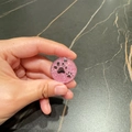 Round pink glitter pet ID tag with a black paw print design and silver metal frame - Pink