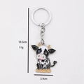Cartoon cow metal keychain with black and white spots and silver ring, 10.5cm long - Crouching Cow