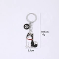 Detail van de Husky-sleutelhanger met poot hanger en 10,5 cm afmetingen weergegeven - Zwart Witte Husky met Zwarte Poot Bedel