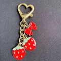 Pastel strawberry keychain with golden heart clasp and a cute red bow ornament - Strawberry Bow Style