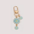 Porte-clés marguerite avec pétales bleu clair et fermoir doré au style forêt mignonne - Marguerite Bleue
