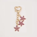 Portachiavi dorato con chiusura a cuore e tre ciondoli a forma di stella marina viola - Stile Moschettone a Cuore / Stella Marina Viola