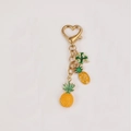 Golden keychain with pineapple, strawberry, and four-leaf clover charms and heart clasp - Pineapple with Clover