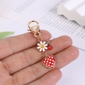 Cute metal keychain featuring a ladybug, daisy, and red heart charm for bags and keys - Heart Ladybug