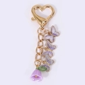 Gold heart-shaped keychain with purple enamel butterflies and lily of the valley charm - Purple Butterfly