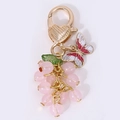 Roze druiven sleutelhanger met gouden harthaak en decoratief vlinderaccentje - Roze