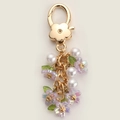 Floral keychain featuring purple resin petals and white pearls with golden clasp hardware - Purple Flower Pearl String