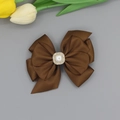 Detail einer dunkelbraunen Satin-Schleifen-Haarklammer mit Perle und Strasssteinen - Kaffeebraun