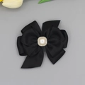 Dettaglio fermaglio a fiocco nero con perla quadrata e strass su sfondo grigio - Nero