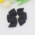 Détail d'une pince à cheveux nœud en satin noir avec strass brillants sur fond blanc - Noir