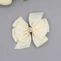 Detailansicht der cremefarbenen Satinschleife mit Perlen- und Strassblumen-Verzierung - Beige