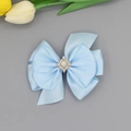 Détail d'une pince à cheveux en satin bleu clair avec cristal central et diamants - Bleu